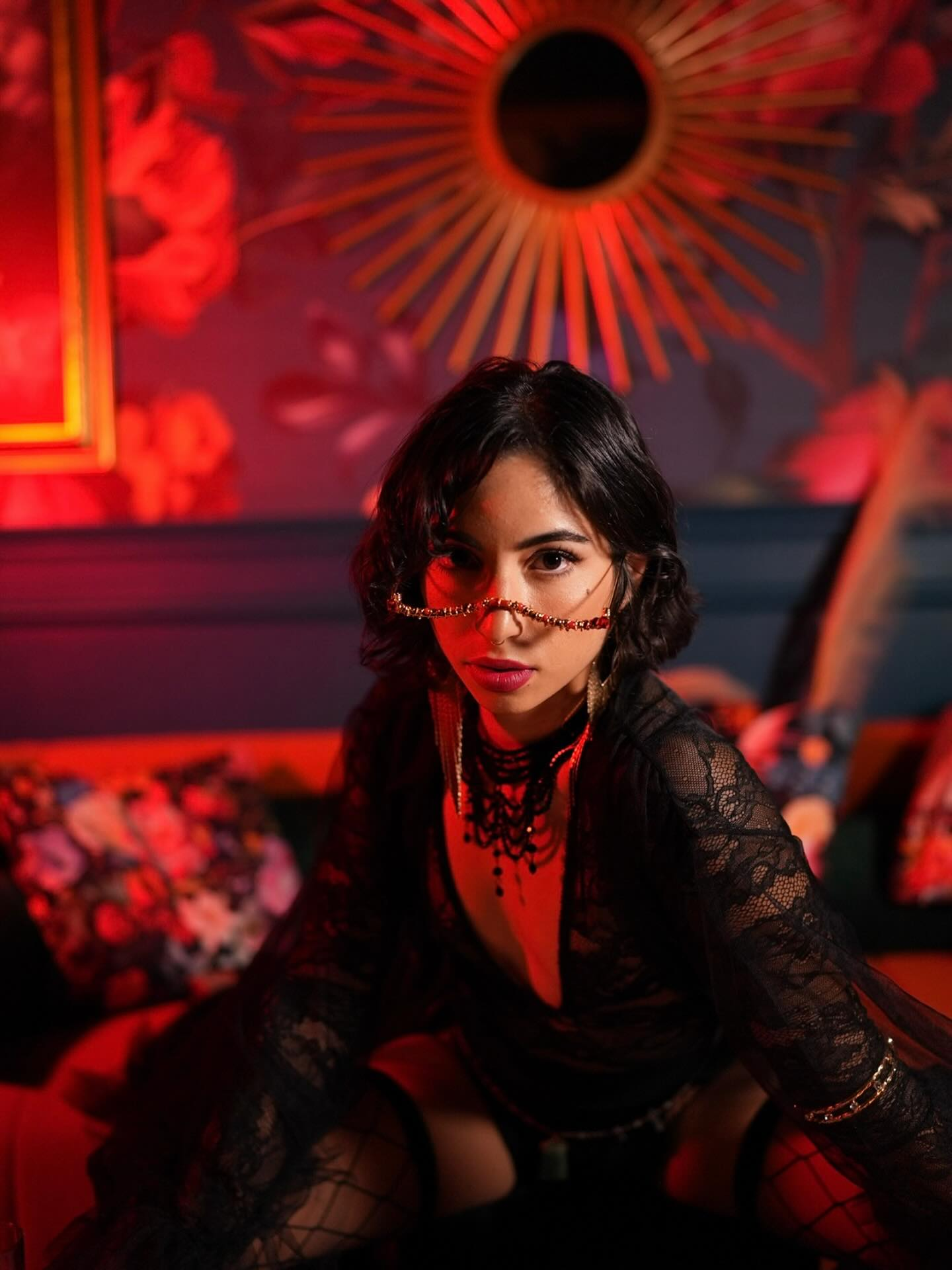 Portrait of Selene Ashé in a dimly lit, red-hued room